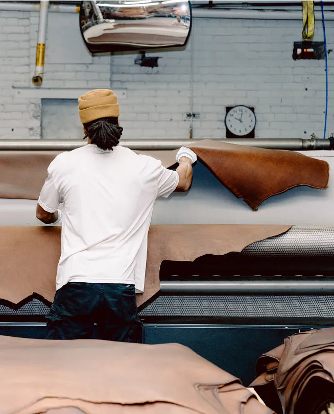 A man working with leather at a machine