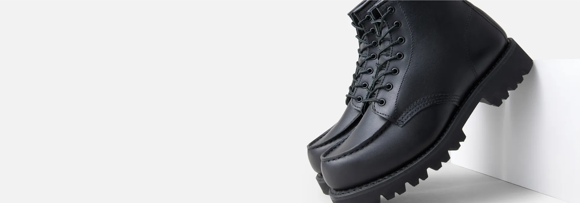 A pair of black Porter Moc boots leaning against a white background