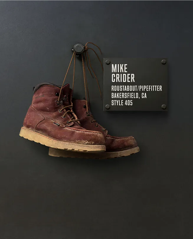 Mike Crider's boots hanging on the Wall of Honor by a plaque with information