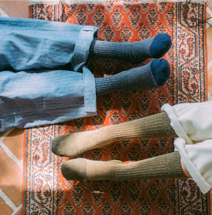 Overhead view of 2 pairs of feet wearing socks