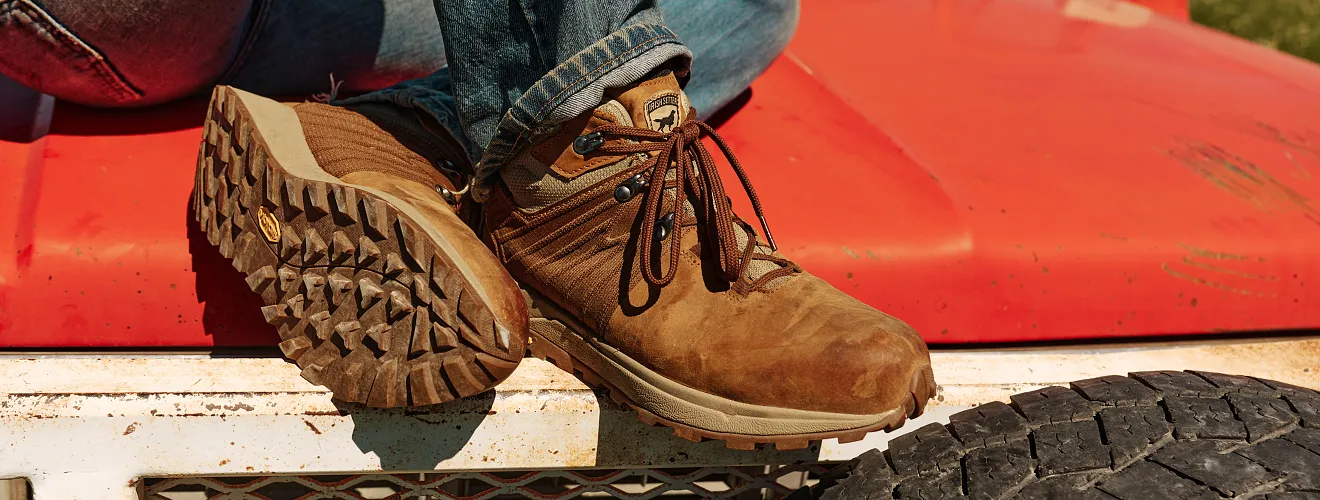 Close up of Cascade boots someone is wearing while sitting on a car