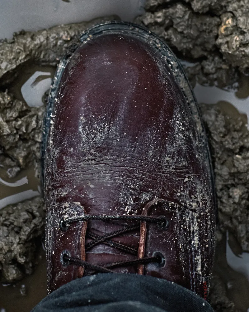 Close-up of boot toe in mud