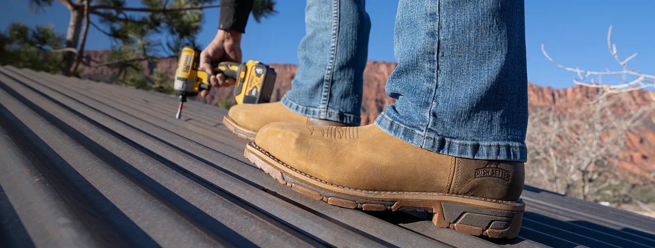 Person using a drill on a roof wearing Marshall boots