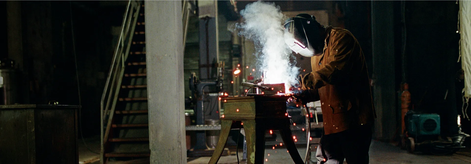 A person in a workshop welding