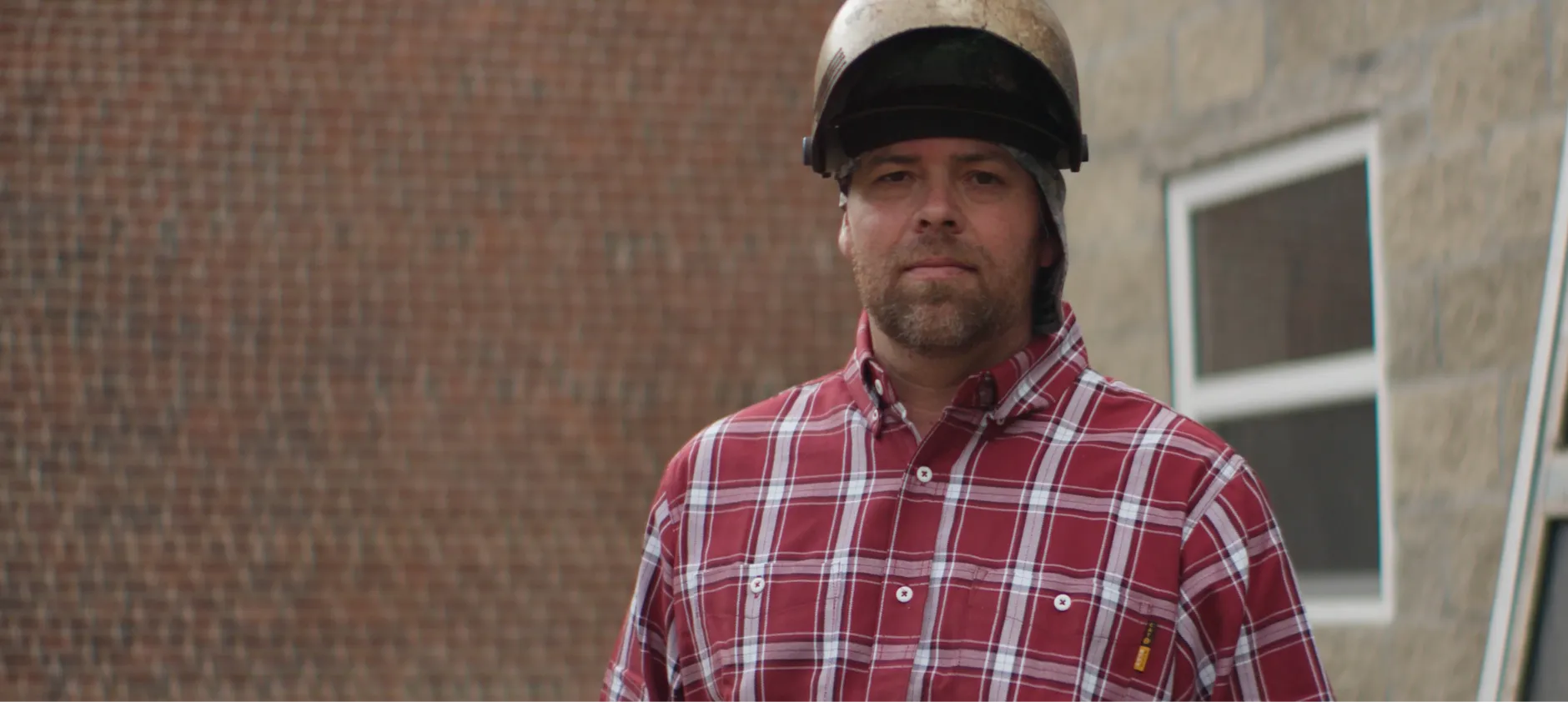 Closeup picture of Kevin Westling wearing a welding helmet