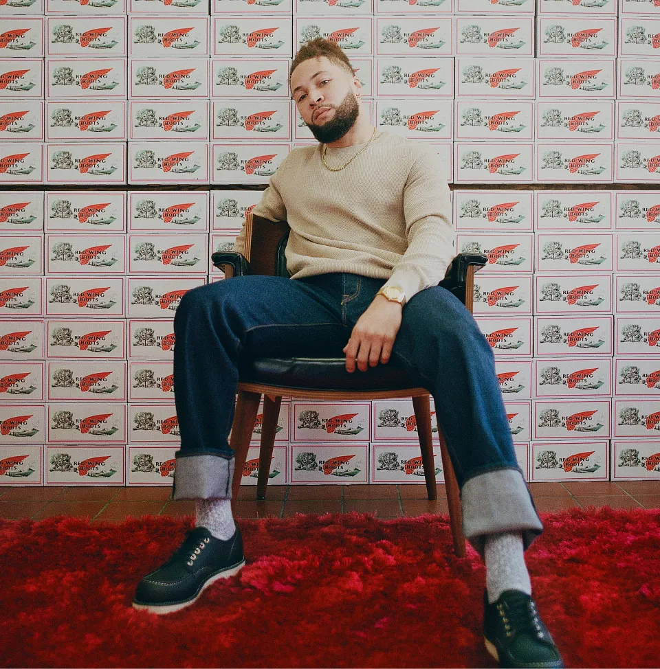 A man sitting on a chair in front of many boxes piled up