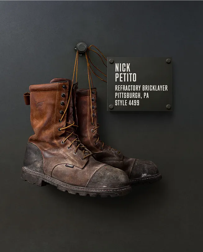 Nick Petito's boots hanging on the Wall of Honor by a plaque with information