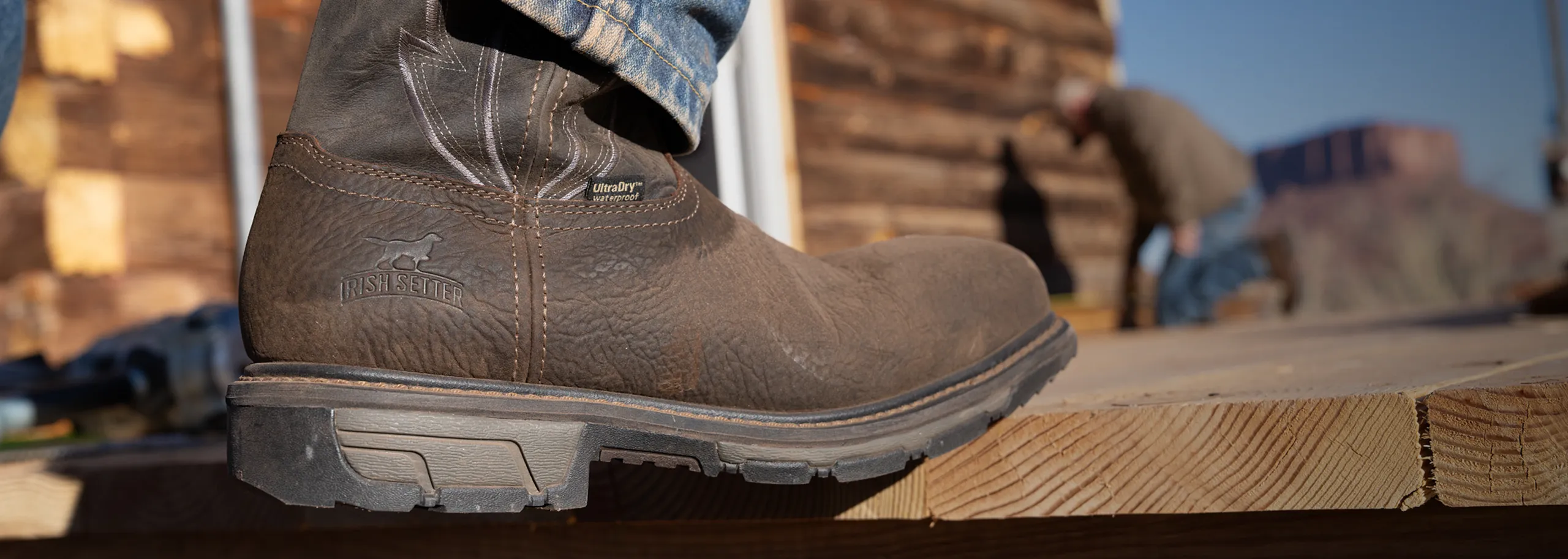 Close up of a Marshall Boot stepping onto a deck with another person in the background