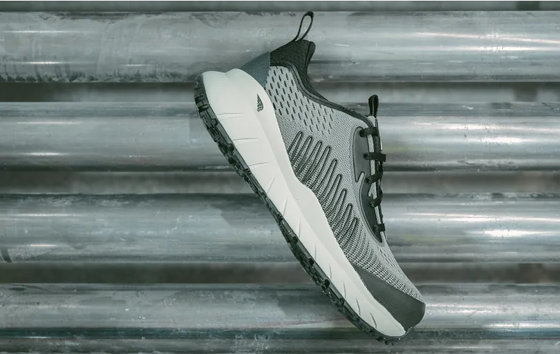 One shoe floating in front of a metal background