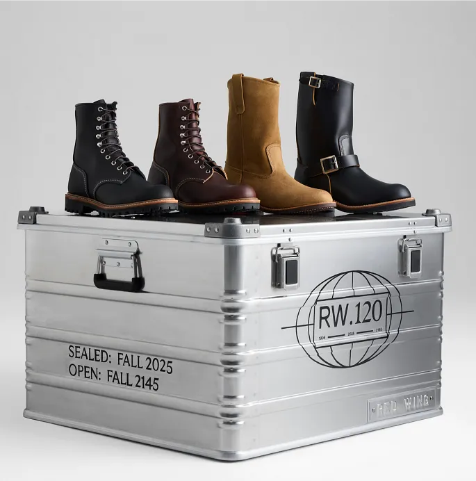 A metal box with 4 different boots sitting on top of it against a white background