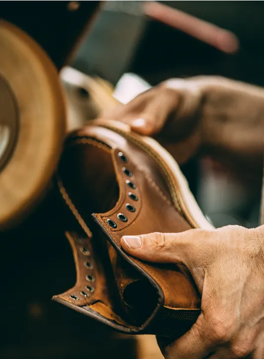 Hands holding a boot at a machine