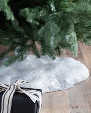 Un pied de sapin de Noël orné d'un tissu imitation neige