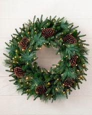 decorated greenery wreath with clear LED lights and pinecones