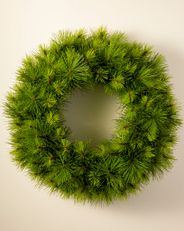 an unlit artificial wreath with pine needles