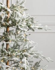 schneebedeckter Weihnachtsbaum mit LED-Mini-Lichtern
