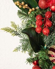 Nahaufnahme eines künstlichen Weihnachtszweigs mit traditionellen Nadeln und Weihnachtsdekoration