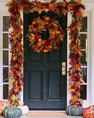 fall-themed greenery wreath and garland on a front door