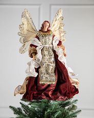 An angel tree topper atop a Christmas tree