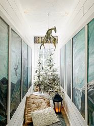 a pair of sparse Christmas trees in a reading nook
