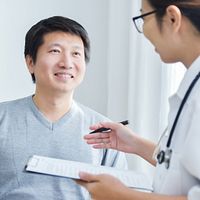 Doctor speaking with a patient in an exam room.