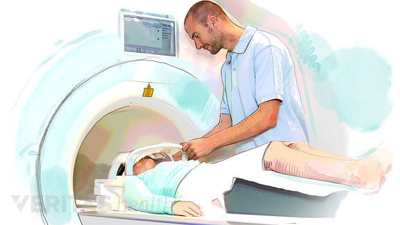 Patient entering an MRI scanner with technician.