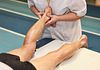 Therapist doing myofascial release therapy on a man's ankle