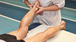 Therapist massaging the achilles tendon.