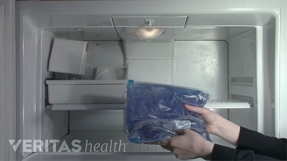 An icepack being placed in the freezer