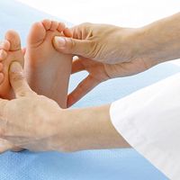 Doctor checking the alignment of a child's foot.