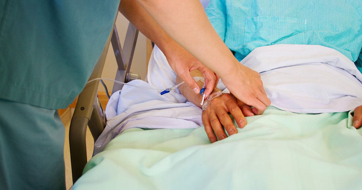 nurse adjusting intravenous tubing