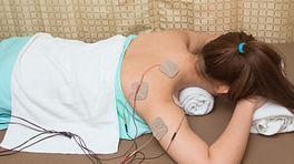 Portable TENS device applied to right shoulder