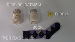 Items to make a homemade heat pack include uncooked rice or oatmeal, thread, and a sock