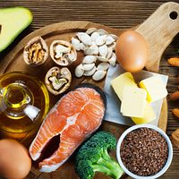 Spread of healthy foods including broccoli, salmon, eggs, olive oil, chia seeds, and avocado