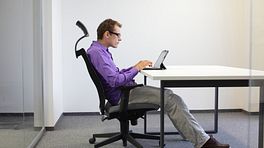 Man sitting at a desk with incorrect posture