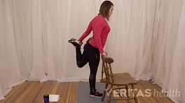 Woman doing standing quad stretch with a stretch.