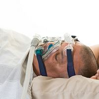 Man asleep with a sleep apnea machine.