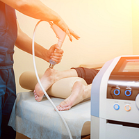 Image of a physician performing ESWT on a patient's heel