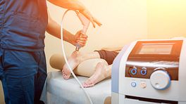 Physician performing shockwave therapy on a patient's heel
