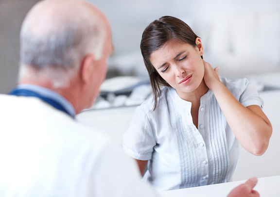 woman with neck pain at doctor consultation