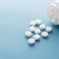 Over the counter ibuprofen bottle and pills scattered