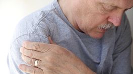 Older man grabbing his shoulder in pain.