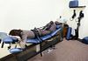 Woman lying prone on a spinal decompression chair
