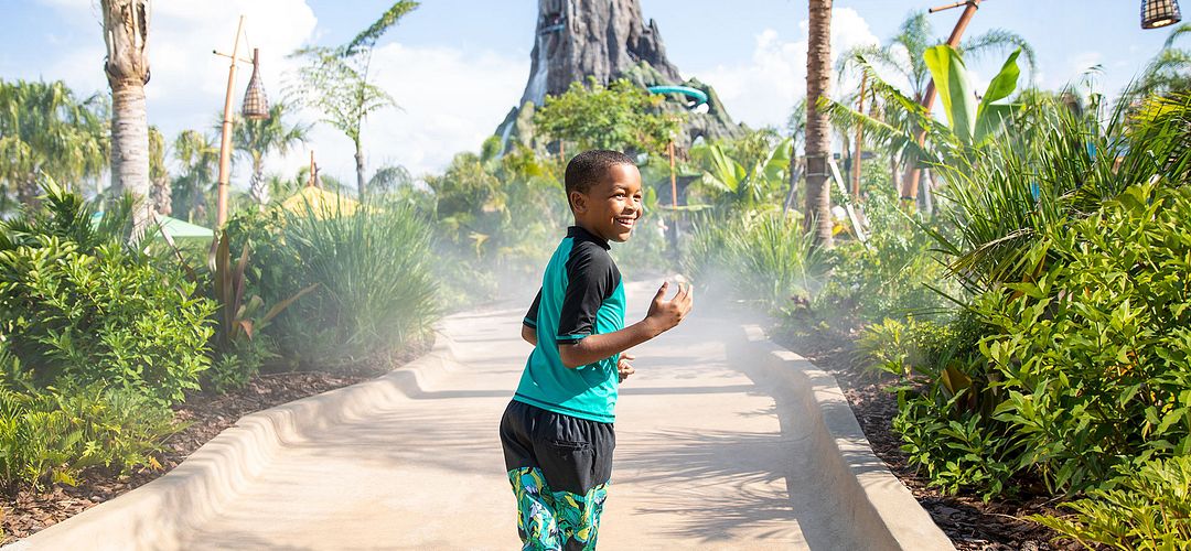 Universal's Volcano Bay™ Honu Ika Moana walkway Boy walking on Honu Walkway to attraction at Volcano Bay at Universal Orlando Resort