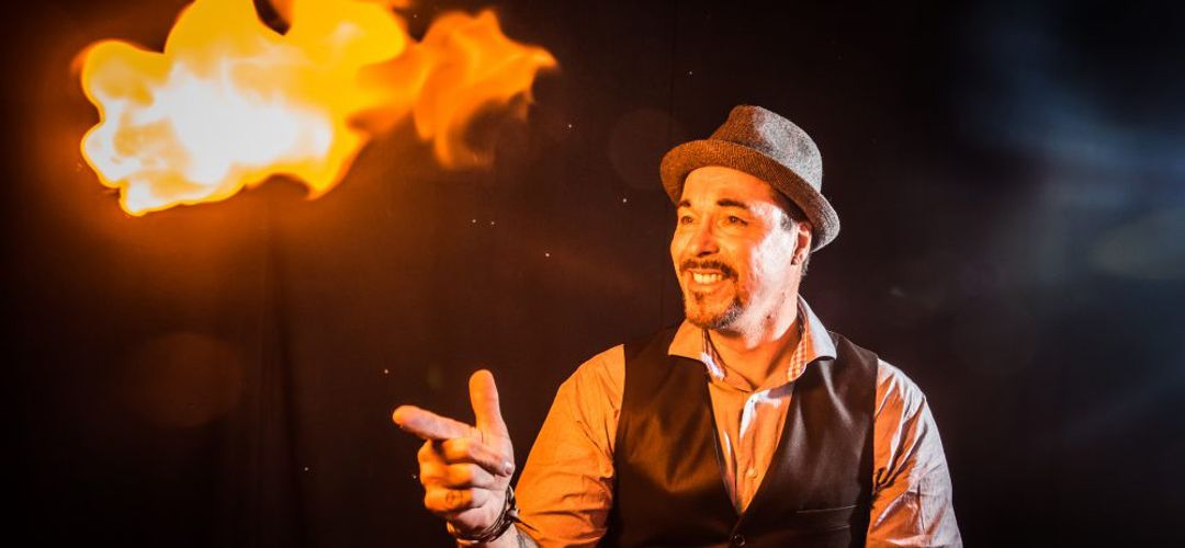 WonderWorks Orlando A magician performing a fire trick at the Outta Control Magic Comedy Dinner Show.