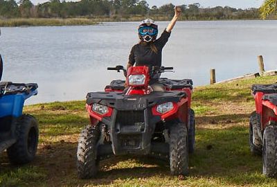 Group posing for a photo on ATVs at Revolution Adventures