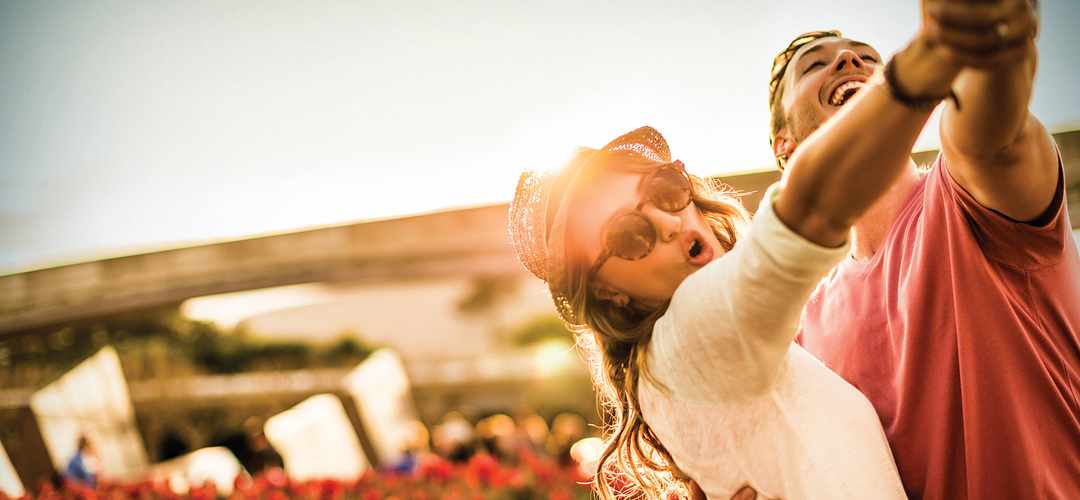 Una pareja joven bailando Una pareja joven bailando bajo la puesta del sol en un día lleno de diversión en Epcot.