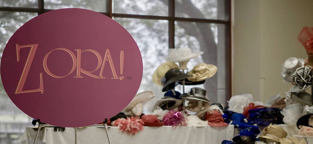 Zora Festival Sign Indoor Zora Festival sign by a table of decorative hats