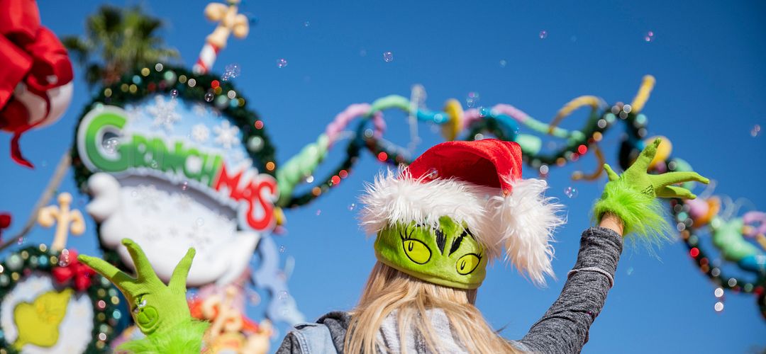 Grinchmas at Universal Orlando Resort A girl in a Grinch hat celebrates Grinchmas at Seuss Landing at Islands of Adventure.