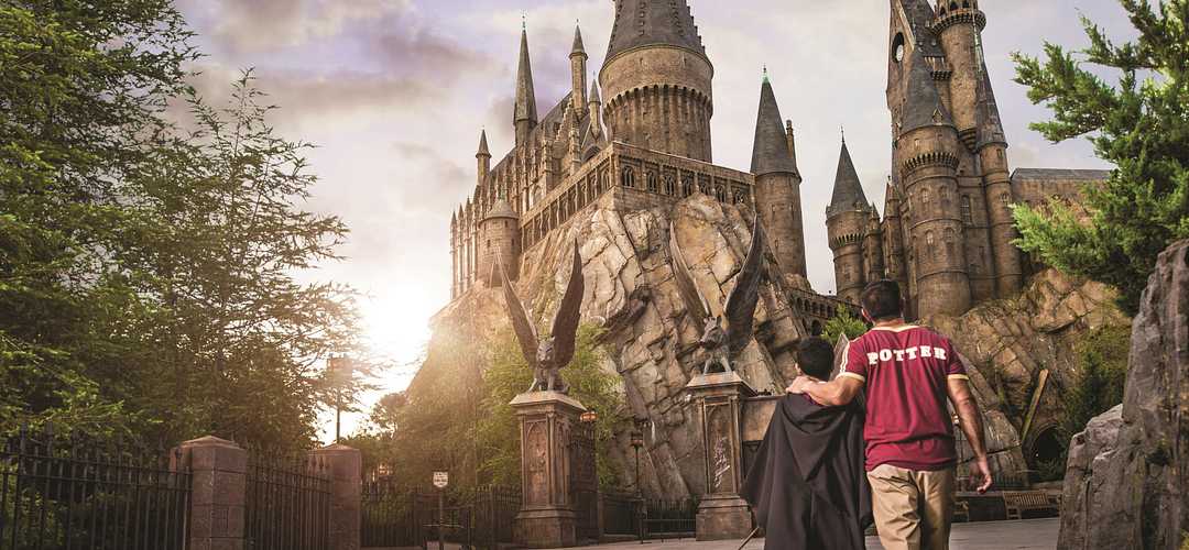 The Wizarding World of Harry Potter™ Papá e hijo caminando hacia la atracción de Harry Potter en Islands of Adventure
