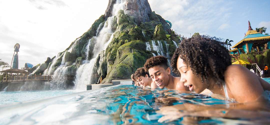 Reef Leisure Pool at Universal's Volcano Bay Teens gazing into Reef Leisure Pool with the volcano in the background
